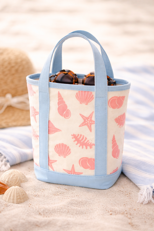 Beach-themed tote bag with shell pattern on sand