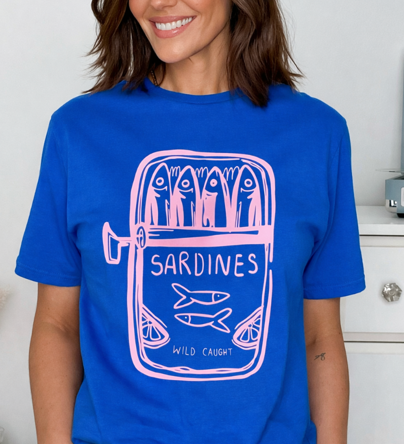 Person wearing a blue t-shirt with a 'Sardines' graphic design.